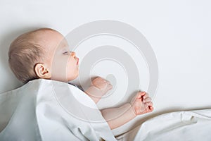Baby sleeps on bed. Infant development concept, toddler restful sleep, teething, colic