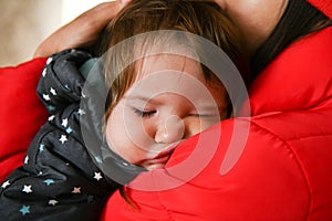 The baby sleeps in her mothers arms. after a walk. Close-up. Sleeping Baby. Newborn baby sleeps in her mothers arms
