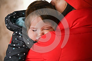 The baby sleeps in her mothers arms. after a walk. Close-up. Sleeping Baby. Newborn baby sleeps in her mothers arms