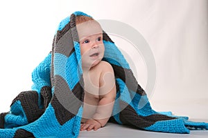 Baby Smiling Lying on Stomach With Blanket on White Background