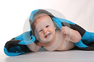 Baby Smiling Lying on Stomach With Blanket on White Background