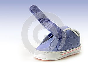Blue baby shoe with open velcro strap, isolated, clipping path included.