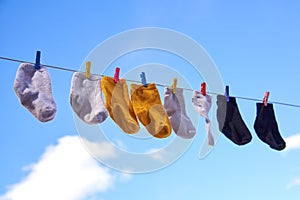 Baby socks dry on the street against a blue sky