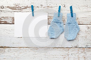 Baby socks hanging on white wooden background. Flat lay