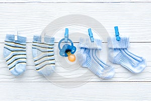 Baby socks on rope at wooden background