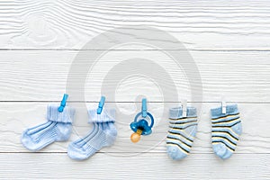 Baby socks on rope at wooden background