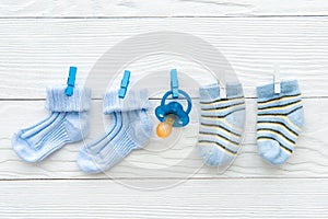 Baby socks on rope at wooden background