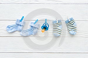 Baby socks on rope at wooden background