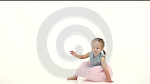 Baby is spinning in the studio and falls to the floor. White background. Slow motion