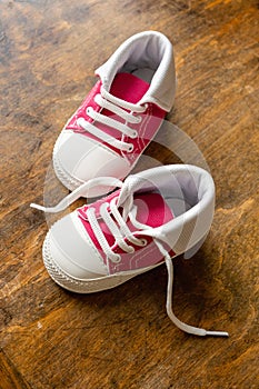 Baby shoes on wood, closeup above view