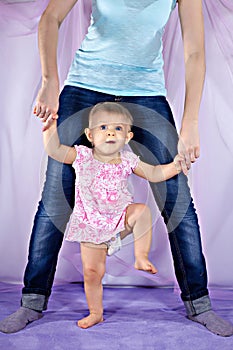 Baby standing between mother's legs