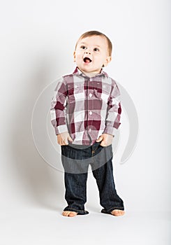 Baby Stands in Flannel and Jeans Looking Left