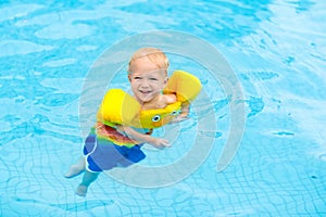 Baby in swimming pool. Kids swim.