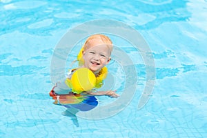 Baby in swimming pool. Kids swim.