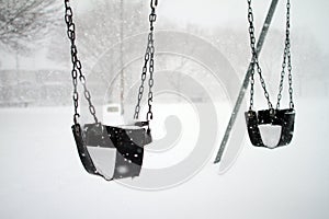 Baby swings covered with snow