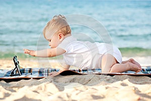 Baby with tablet pc on the beach.