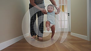 baby takes the first steps to learn. happy family kid dream concept. mom teaches baby light newborn to walk and take