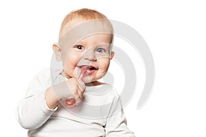 Baby teeth care. Smiling boy brushing his teeth with a toothbrush for infant. Isolated portrait