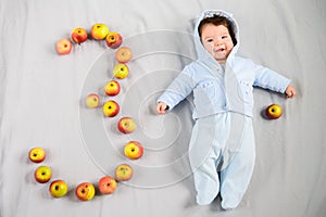The baby is three months old. 3 months cute baby portrait. Numeral 3
