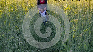 Baby to learn to walk in a rapeseed field slow motion