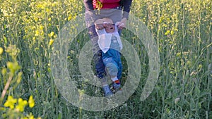 Baby to learn to walk in a rapeseed field Slow motion
