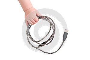 Baby toddler boy holds a usb cable in his hand to charge his phone, iso