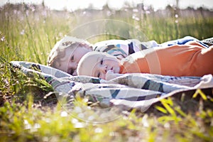 Baby and toddler brothers lying on quilt