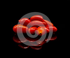 Baby tomatoes,cherry tomatoes and water drop on black background with reflection