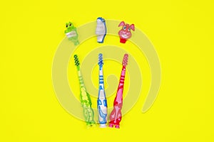 Baby toothbrushes on yellow background
