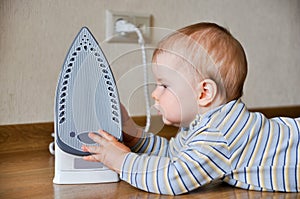 Baby touching hot iron photo