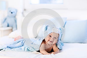 Baby in towel after bath in bed