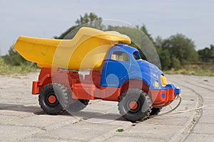 Baby toy dump truck on sunny road