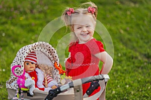 baby with toy stroller and doll