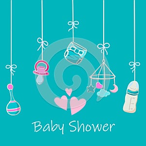 Baby toys, diaper, milk bottle and soother on the strings on the turquoise background.