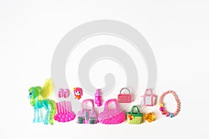 Baby toys of a little girl.Accessories for dolls in pink range on a white background. Children`s fantasies.