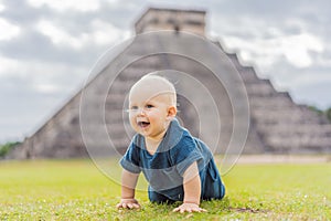 Baby traveler, tourists observing the old pyramid and temple of the castle of the Mayan architecture known as Chichen