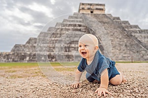 Baby traveler, tourists observing the old pyramid and temple of the castle of the Mayan architecture known as Chichen