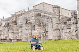 Baby traveler, tourists observing the old pyramid and temple of the castle of the Mayan architecture known as Chichen