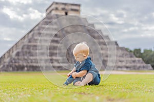 Baby traveler, tourists observing the old pyramid and temple of the castle of the Mayan architecture known as Chichen