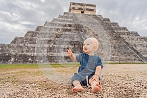 Baby traveler, tourists observing the old pyramid and temple of the castle of the Mayan architecture known as Chichen