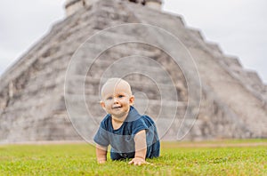 Baby traveler, tourists observing the old pyramid and temple of the castle of the Mayan architecture known as Chichen