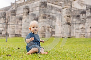 Baby traveler, tourists observing the old pyramid and temple of the castle of the Mayan architecture known as Chichen