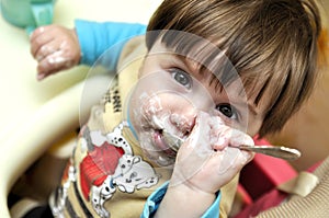 Baby tries to eat yoghurt independently