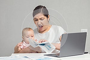 Baby tries to get attention from mother working on laptop