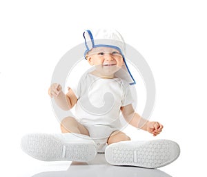 Baby trying on shoes and basebal cap