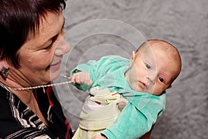 Baby trying to steal grandmothers necklace photo