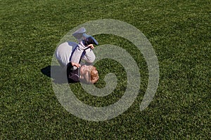 Baby tumbles on green artificial cover outdoors