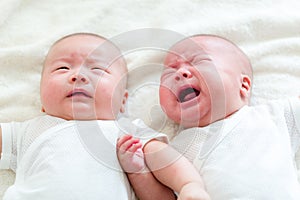 Baby twins, one crying and one quiet