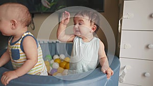 baby twins play in a dry ball pool. happy family kid dream concept. baby smiling play in dry pool at home indoors two