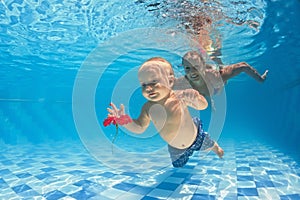 Baby underwater swimming lesson with instructor in the pool